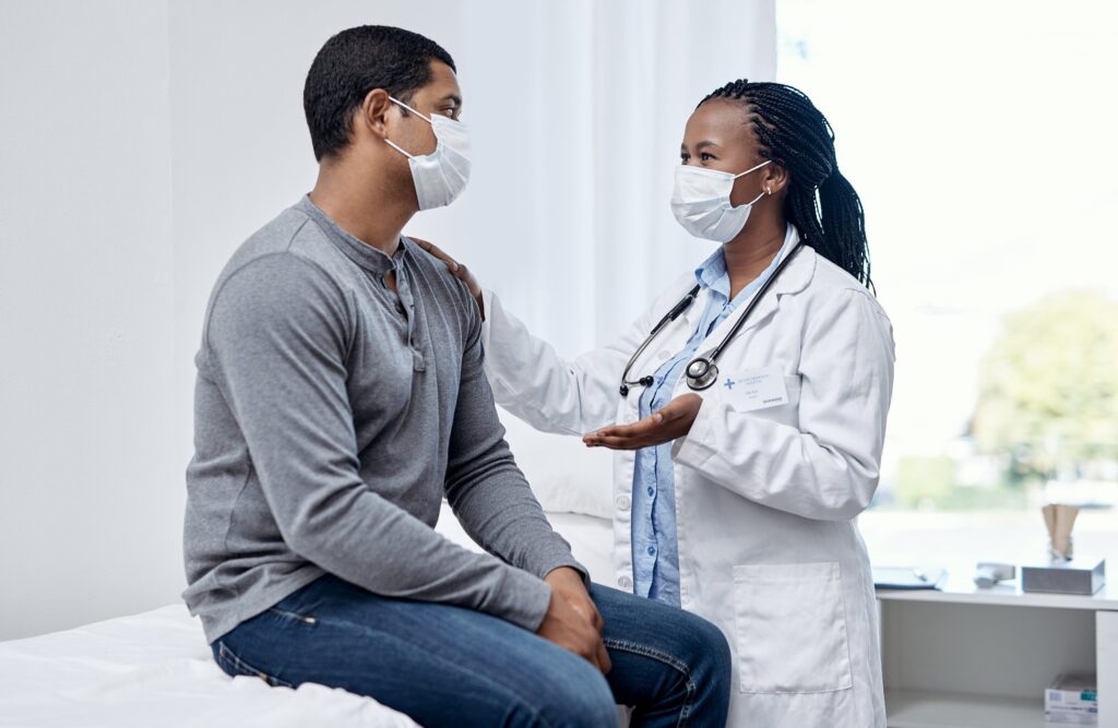 female doctor wearing mask consulting a men wearing mask